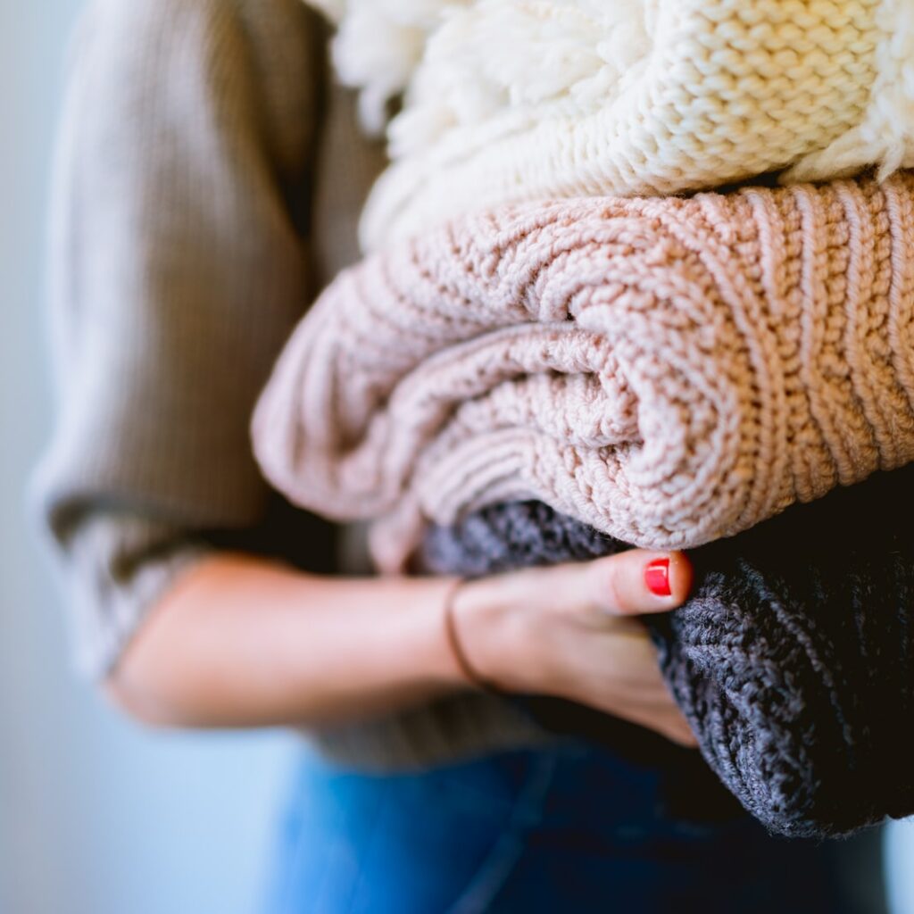 person holding knitted textiles